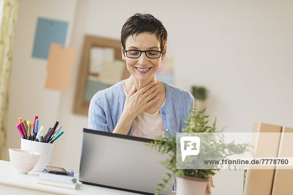Frau mit Laptop im home-office Heimarbeitsplatz