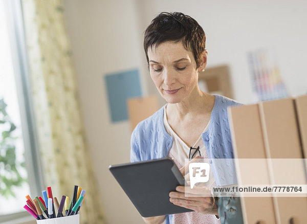 Woman using digital tablet in home office