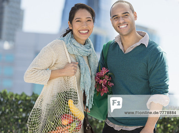 Portrait of happy couple with grocery shopping bags