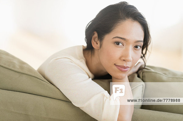 Portrait einer jungen Frau auf Couch sitzen