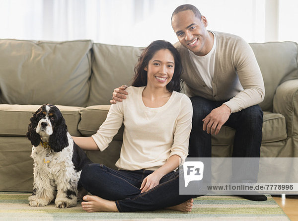 Young couple with dog in living room