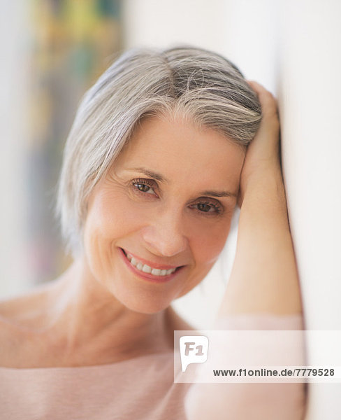 Portrait of relaxed woman leaning against wall