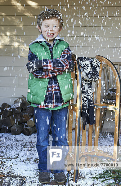 Junge mit Holzschlitten im Schnee