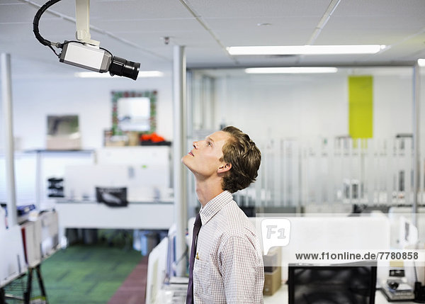 Geschäftsmann untersucht Sicherheitskamera im Büro