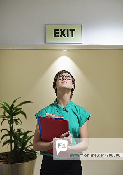 Geschäftsfrau steht unter dem Schild'exit'.