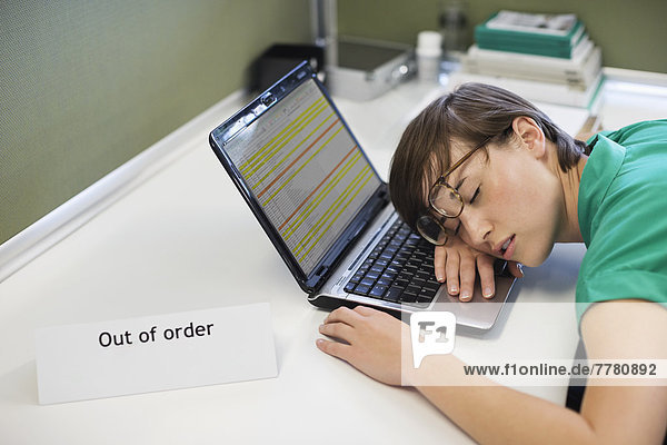 Geschäftsfrau schläft auf'out of order' Laptop