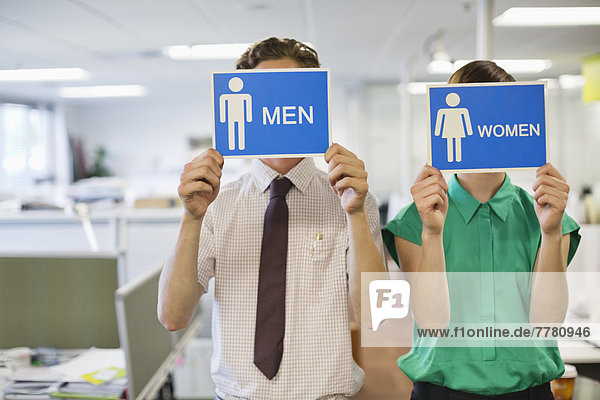 Geschäftsleute mit Männer - und Frauen -Schildern
