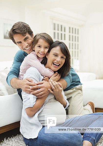 Family hugging in living room