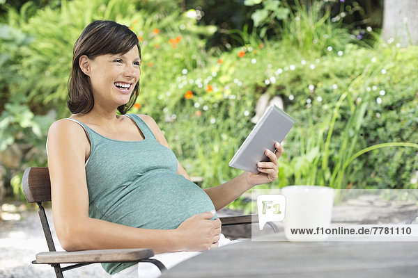 Schwangere Frau mit Tablet-Computer