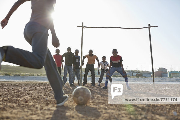 Jungs spielen zusammen Fußball auf dem Feld.