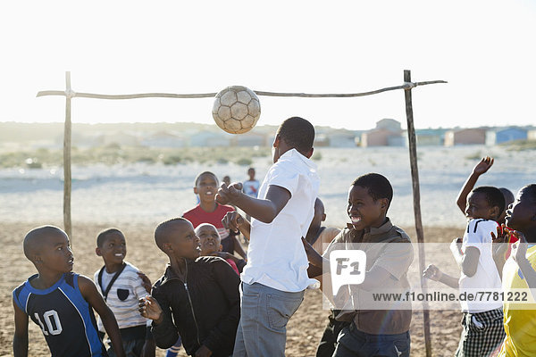 Jungs spielen zusammen Fußball auf dem Feld.