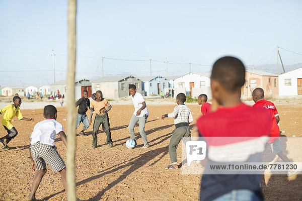 Jungs spielen zusammen Fußball auf dem Feld.