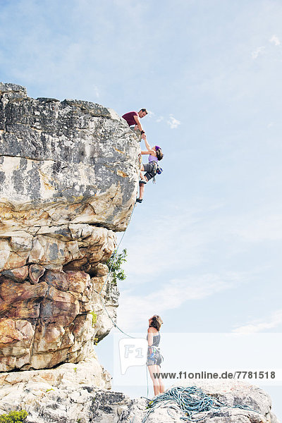 Climbers scaling steep rock face