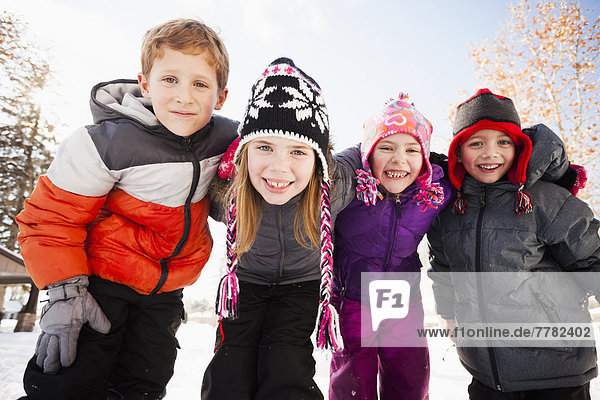 Caucasian children smiling in snow