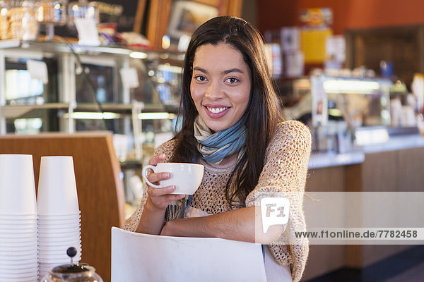 Mixed race woman sitting in coffee shop
