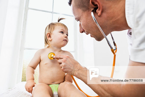 Arzt untersucht Kleinkind Mädchen mit Stethoskop