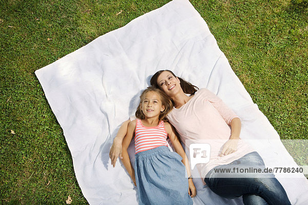 Mutter und Tochter auf Decke liegend  hoher Winkel