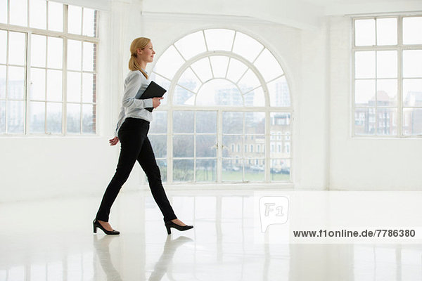 Businesswoman walking in sparse white room