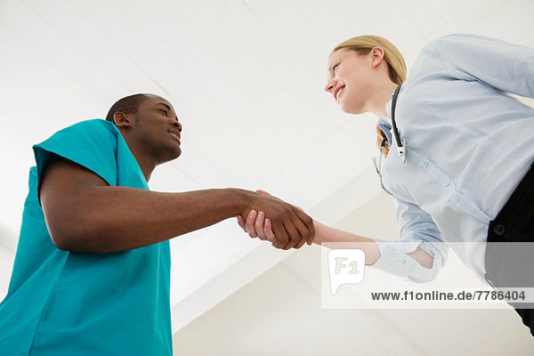 Two doctors shaking hands  low angle