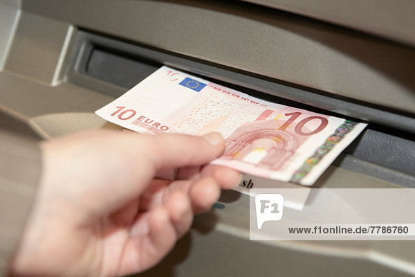 Frau zieht zehn Euro-Banknote aus