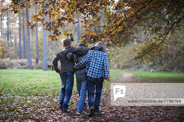 Jungen  die durch den Wald laufen und sich gegenseitig umarmen.