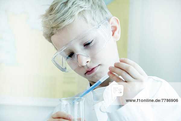 Junge mit Schutzbrille beim wissenschaftlichen Experiment