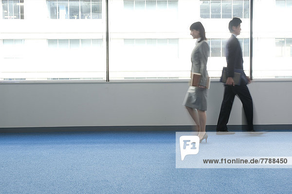 Businessman and woman walking through the office