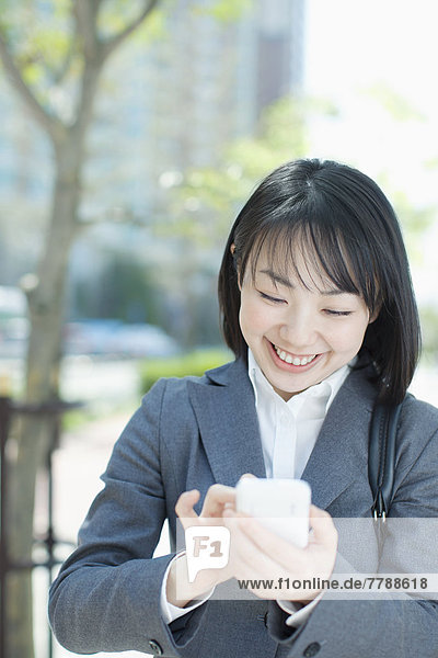 Lächelnde Geschäftsfrau schreibt eine SMS