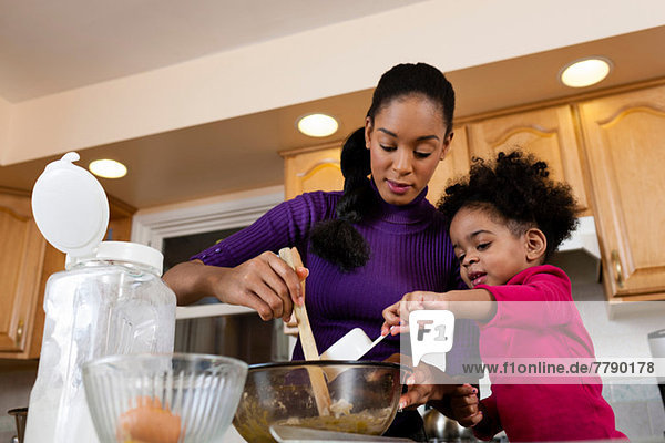 Mother and daughter baking cookies in kitchen