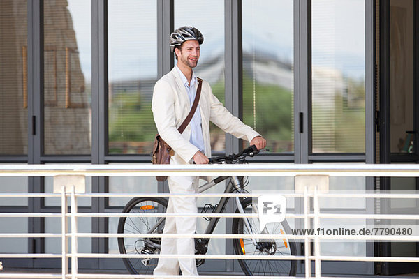 Young man by railing with bicycle