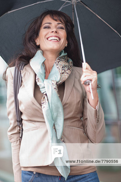 Mid adult woman holding umbrella