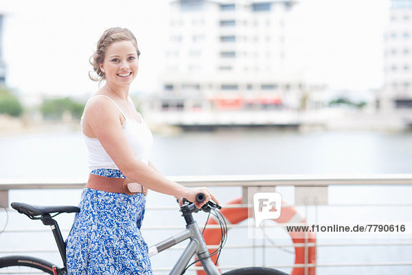 Eine junge Frau mit ihrem Schiebefahrrad