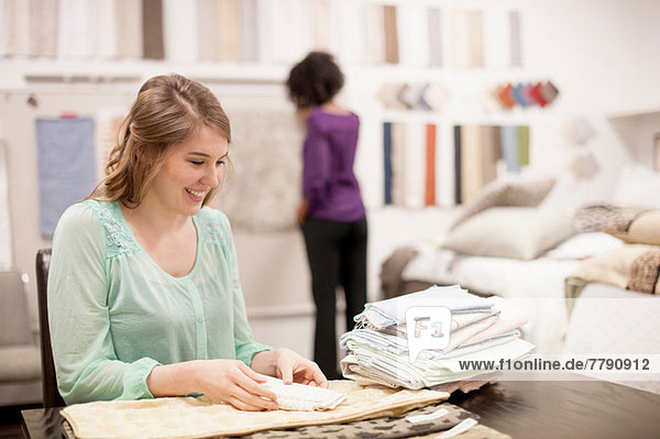 Young woman at desk with fabric samples