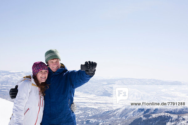 Young couple photographing selves  Brighton ski resort  Utah  USA