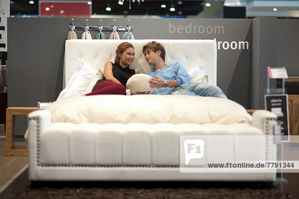 Couple shopping for mattress in store