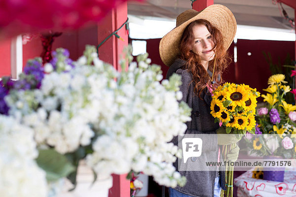 Florist mit Blumenstrauß im Geschäft