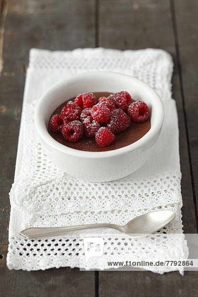Chocolate pudding topped with raspberries