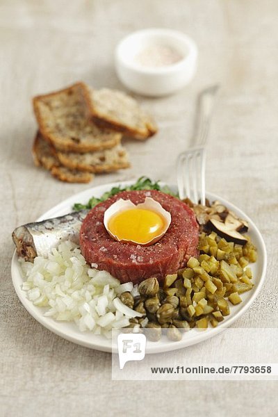 Classic beef tartar with egg  onion  pickled cucumber and mushrooms