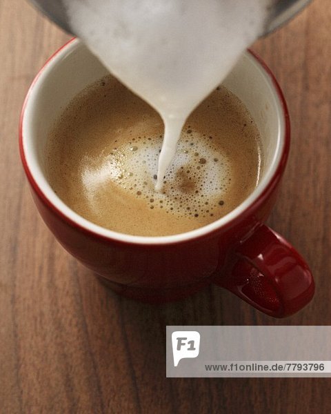 Milchschaum in Espresso giessen