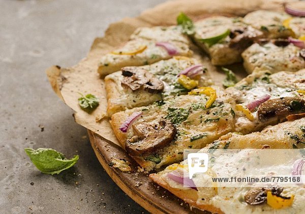 Mushroom  Red Onion  Yellow Pepper and Basil Pizza  Sliced on Pizza Board