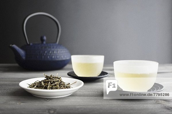 Zwei Tassen Grüntee  Teeblätter und japanische Teekanne
