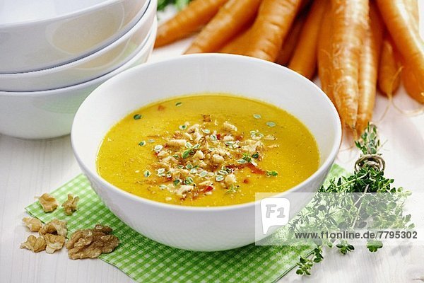 Sellerie-Karotten-Suppe  garniert mit gebratenem Sellerie  Paprika  Nüssen und Thymian