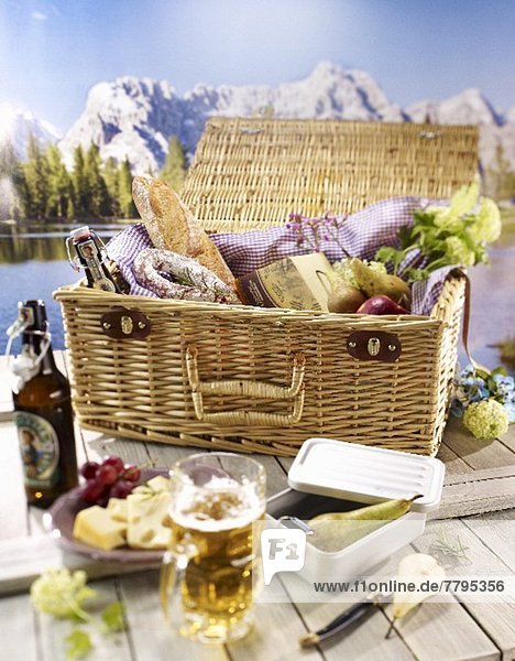 Tisch mit Brotzeit & Picknickkorb vor Bergpanorama