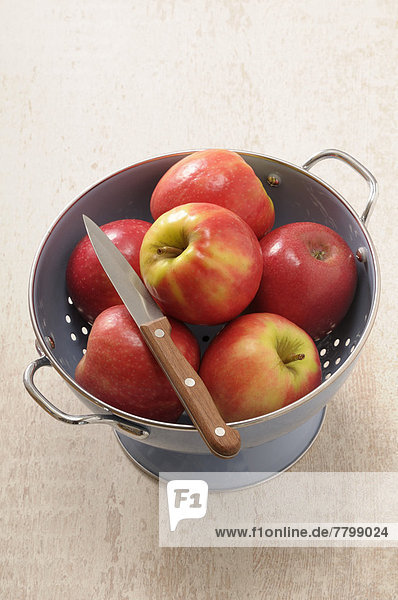 Studioaufnahme  Messer  über  füllen  füllt  füllend  Hintergrund  rot  Ansicht  Küchensieb  Apfel  braun