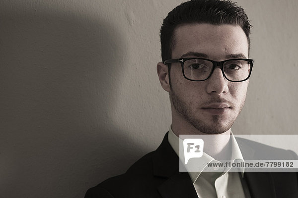Head and Shoulder Portrait of Young Man wearing Glasses  Looking at Camera  Studio Shot