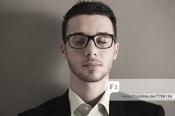 Close-up Portrait of Young Man wearing Glasses with Eyes Closed  Studio Shot
