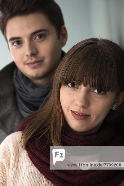 Close-up  Head and Shoulder Portrait of Young Couple Smiling at Camera  Studio Shot on Grey Background