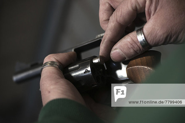 Close-up of Man Loading Bullets into Gun  Mannheim  Baden-Wurttemberg  Germany