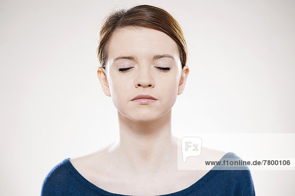 Head and Shoulders Portrait of Teenage Girl with Eyes Closed in Studio