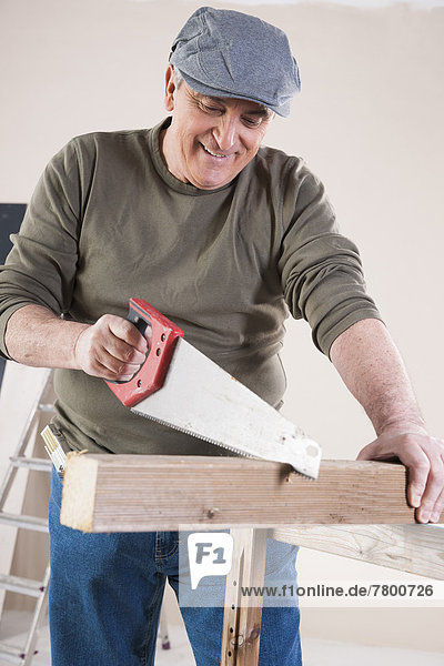 Man Cutting Lumber  Woodworking Project  in Studio